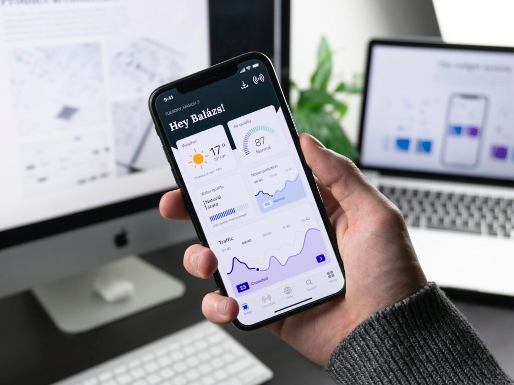 Mano sosteniendo un móvil con el panel de datos de una aplicación